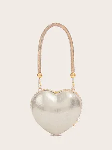 Detailaufnahme der herzförmigen Abendtasche mit Strassgriff und eleganter Metallic-Oberfläche.