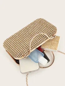 Detailansicht einer goldenen Strass-Abendtasche mit glitzerndem Design und eleganter Kette.