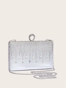 Nahaufnahme Detail der silbernen Abendtasche mit glitzernden Strassfransen und Kette.