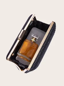 Detailansicht einer eleganten schwarzen Strass Abendtasche mit goldenem Metallrahmen.