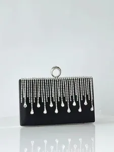 Detailed view of black evening clutch showing sparkling rhinestone fringe and metal lock.