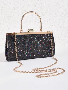 Nahaufnahme einer glitzernden schwarzen Abendtasche mit Goldrahmen und edler Kette.