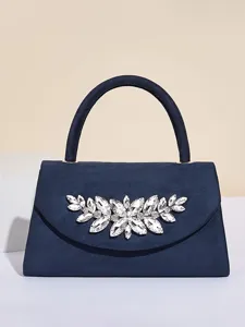 Detailaufnahme der dunkelblauen Abendtasche mit funkelndem Kristallblattemblem eleganter.
