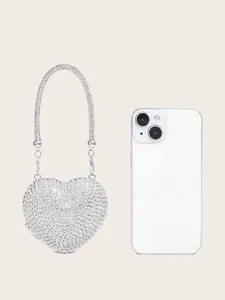 Detailansicht der glitzernden Strass Herz Abendtasche mit Smartphone Größenreferenz.