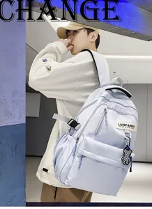Vue détaillée d'un sac à dos étudiant bleu clair avec pendentif ours et compartiments.
