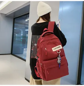 Vue détaillée du sac à dos rouge de grande capacité avec poches pratiques et stylées.