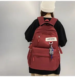 Vue détaillée d'un sac à dos de style campus décontracté avec compartiments spacieux et joli pendentif
