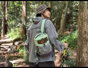 Detailaufnahme vom leichten grünen Wanderrucksack des Models im waldigen Wanderpfad.