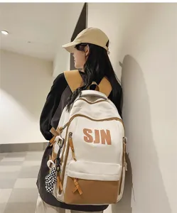 Detail view of the stylish contrast color backpack with spacious compartments and charm.