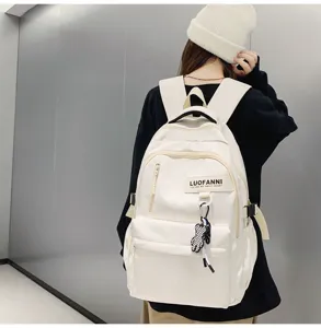 Vue détaillée du sac à dos blanc avec étiquette avant et pendentif ours tendance.