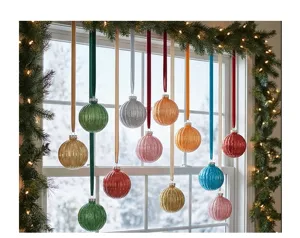 Escena detallada que muestra bolas de Navidad acanaladas de PET colorido con cintas de terciopelo.