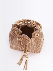 Nahaufnahme der funkelnden goldenen Strass-Eimer Tasche mit Metallring Griff und Quaste.