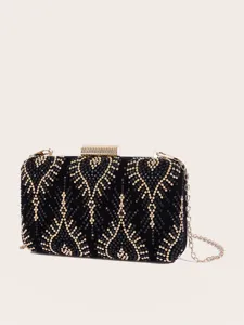 Nahaufnahme der schwarzen Samt-Abendtasche mit funkelnden Strasssteinen und goldener Kette.
