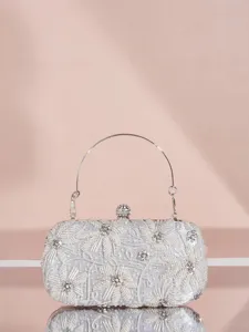 Exquisites Detail einer silbernen Perlen-Clutch mit feiner Stickerei und Strass.