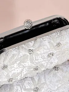 Nahaufnahme der eleganten silbernen Perlen-Abendtasche mit funkelndem Strass-Verschluss.