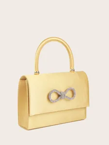 Nahaufnahme Detail der eleganten gelben Satin Abendtasche mit funkelnder Strass Schleife.