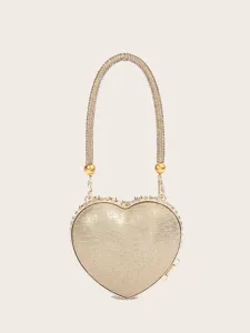 Nahaufnahme einer goldenen herzförmigen Clutch mit funkelndem Strass-Ketten-Griff Detail.