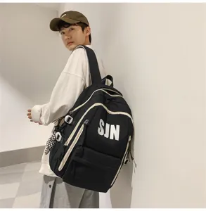 Detailed shot of trendy black large capacity school backpack with white piping and SJN print.