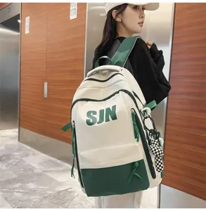 Detailed view of the stylish white and green casual backpack with SJN lettering and charm.