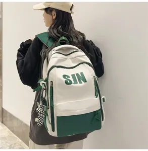 Detail view of a large capacity canvas school backpack in white and green with pockets.