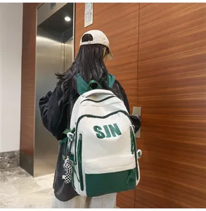 Detailed view of the stylish white and green canvas backpack with bold letter print and straps.