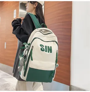 Detail view of the stylish white and green canvas backpack with letters, student casual bag.