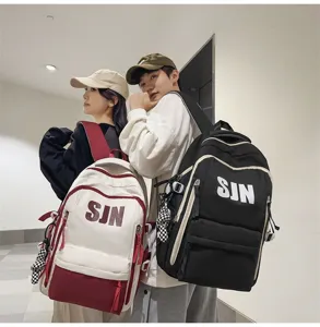 Detail shot of the large capacity casual student backpack showcased by models indoors.