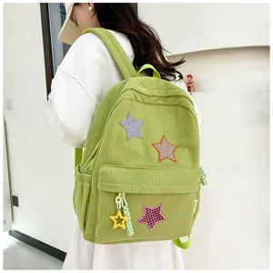 Detailed view of green corduroy backpack with cute star patches and yellow star charm lifestyle.