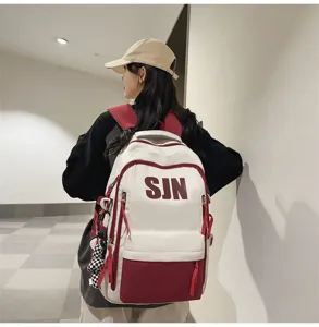 Detailed view of a trendy contrast color large capacity school backpack with SJN print