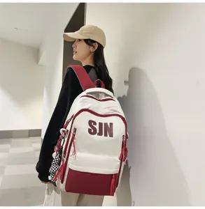 Close-up detail of the stylish white and red student school backpack with large SJN print.