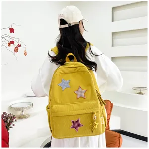 Detail shot of cute yellow corduroy backpack with star patches and soft aesthetic design.