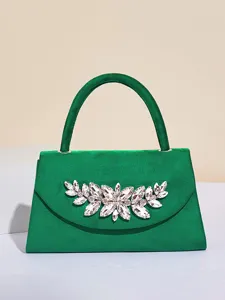 Grüne Samt-Abendtasche Detail, verziert mit einer funkelnden Kristall-Blumenbrosche.