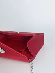 Rote Satin Abendtasche Detailansicht mit Strass-Dekor und silbernem Kettenriemen.
