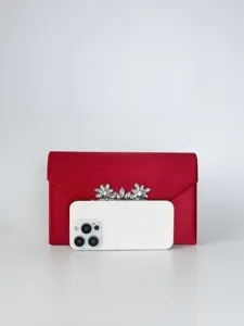 Detailansicht der eleganten roten Satin-Abendtasche mit funkelndem Kristallblumen-Ornament.