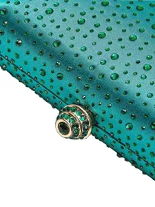 Detailansicht einer türkisen Satin Abendtasche mit grünen Strasssteinen und Schmuckverschluss.