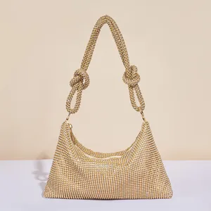 Nahaufnahme der funkelnden Strass-Gold-Abendtasche mit geknotetem Schulterriemen.