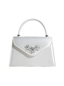 Detaillierte Ansicht der weißen Satin Abendtasche mit funkelnder Kristallblumen Brosche.