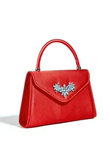 Nahaufnahme der eleganten roten Satin Abendtasche mit funkelnder Kristallblumenbrosche.