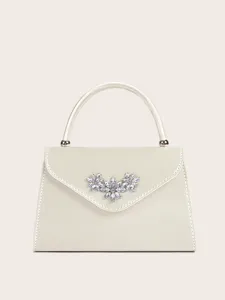 Edles elfenbeinfarbenes Satin Abendtasche Detail mit funkelnder Strass Blumen Dekoration.