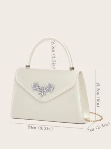 Detailaufnahme der beigen Satin-Abendtasche mit Kristallblüten-Dekor und goldener Kette.