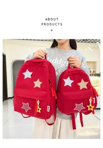 Detailed view of red corduroy backpack with cute star patches and star keychain in bright scene.