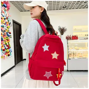 Cute red corduroy backpack detail shot, sweet Japanese style school bag with star patches.