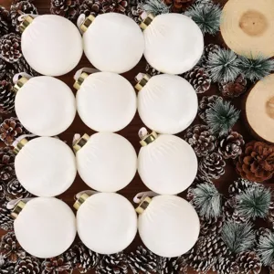Detalle de adorno de bola de Navidad flocada blanca con piñas y fondo de madera.