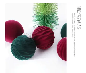 Detalle de bolas de navidad de terciopelo flocado, adornos colgantes rojos y verde oscuro.