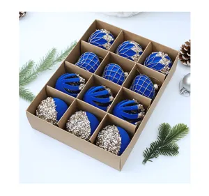 Vista detallada de 12 bolas de Navidad floqueadas azules con decoración de perlas doradas.