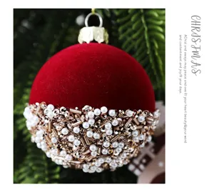 Primer plano de bola de Navidad de terciopelo rojo con ribete de perlas y lentejuelas.