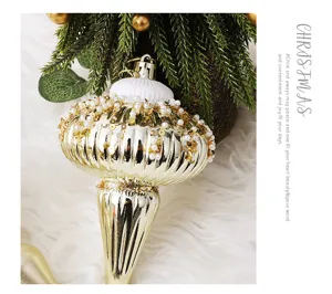 Gros plan d'un ornement de Noël doré luxueux en forme d'oignon avec perles et sequins décoratifs.