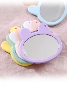 Close-up of cute bunny-shaped makeup mirrors in assorted candy colors, detailing smooth frame.