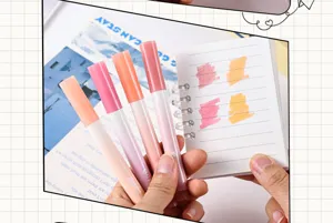 Close-up of aesthetic gradient highlighters testing colors on paper, cute student stationery set.