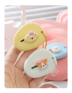 Close-up detail of cute cartoon puppy utility box cutter with bead chain, portable mini craft tool.